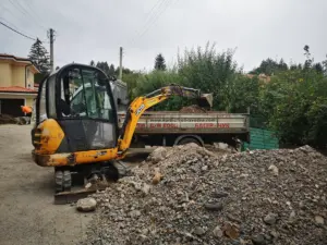 Багер е изкопал доста пръст и пълни камион кърти дум